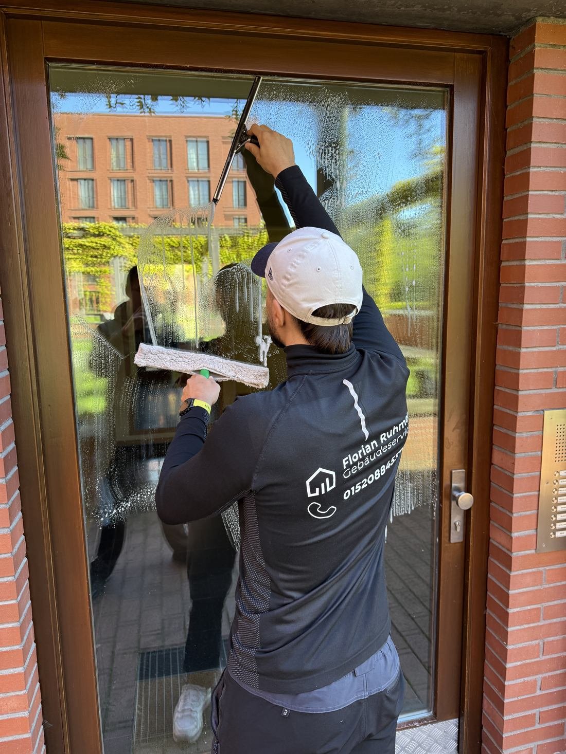 Fensterreinigung mit Abzieher an einer Glastür